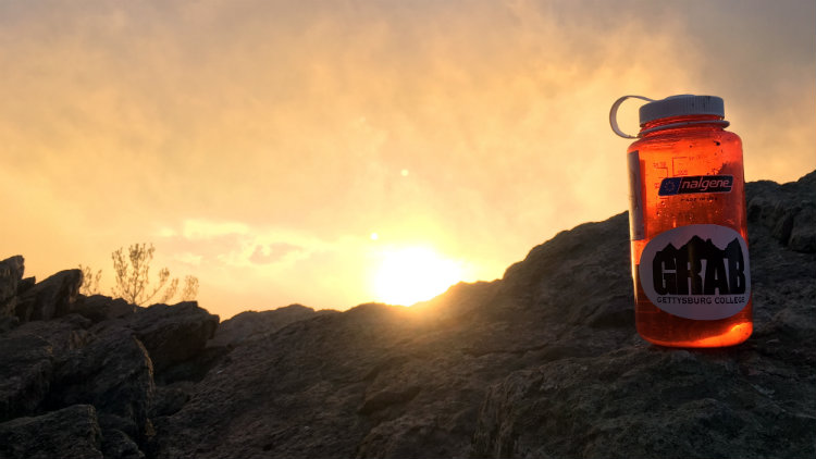 Sun setting behind a mountain on a GRAB hike.